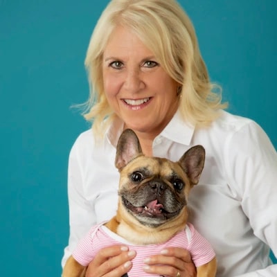 Nancy Saxton-Lopez, veterinary social worker and grief counselor, holding her French Bulldog